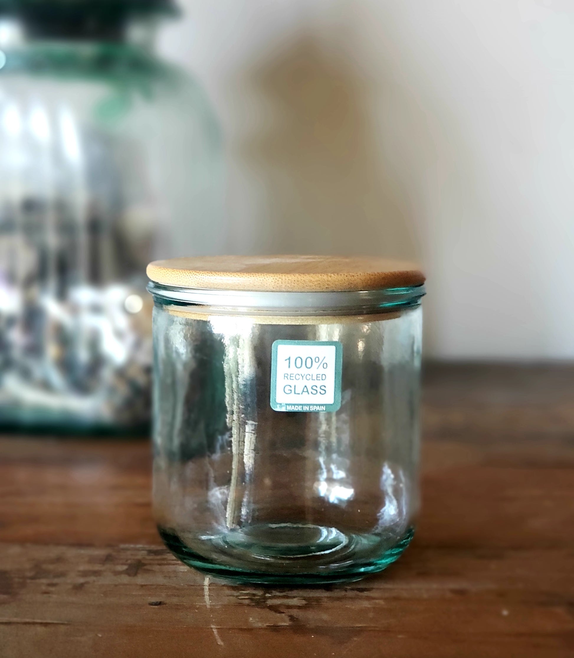 Up close photo of recycled glass jar with wood lid that is used in all of our California Road Trip candle line.